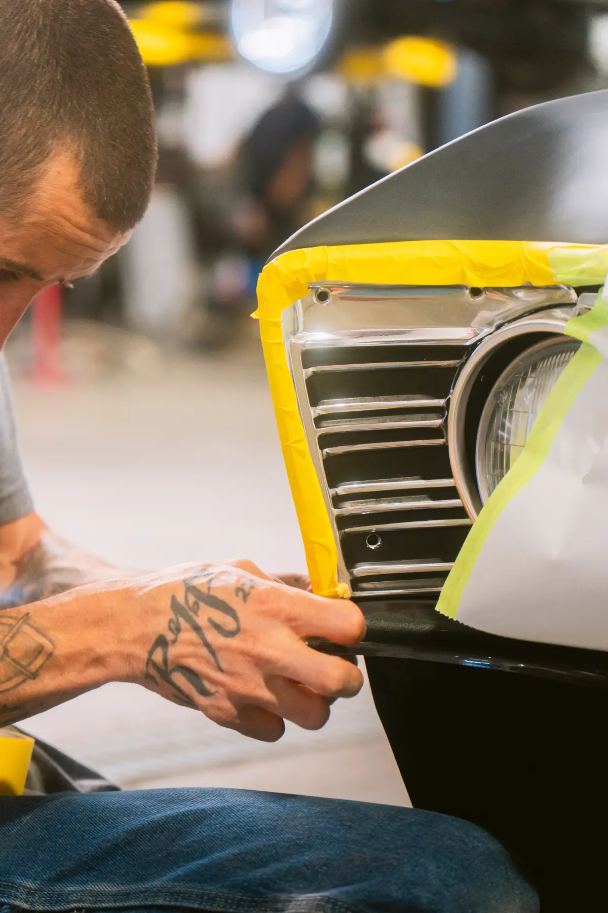 Technician finishing a panel in the Kreations Auto Body paint booth