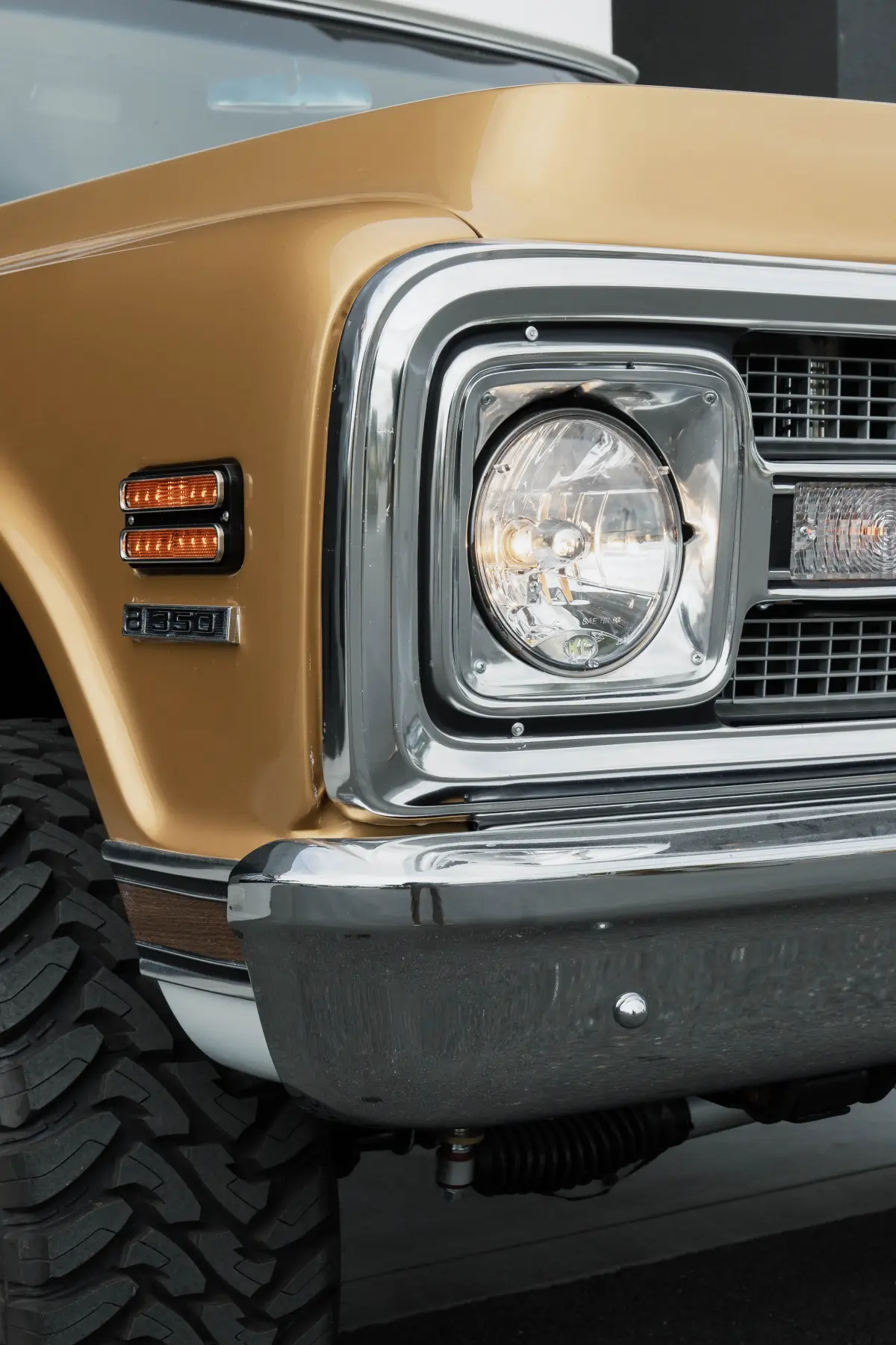 Headlight and grille detail on a gold Chevrolet C10 pickup at Kreations Auto Body