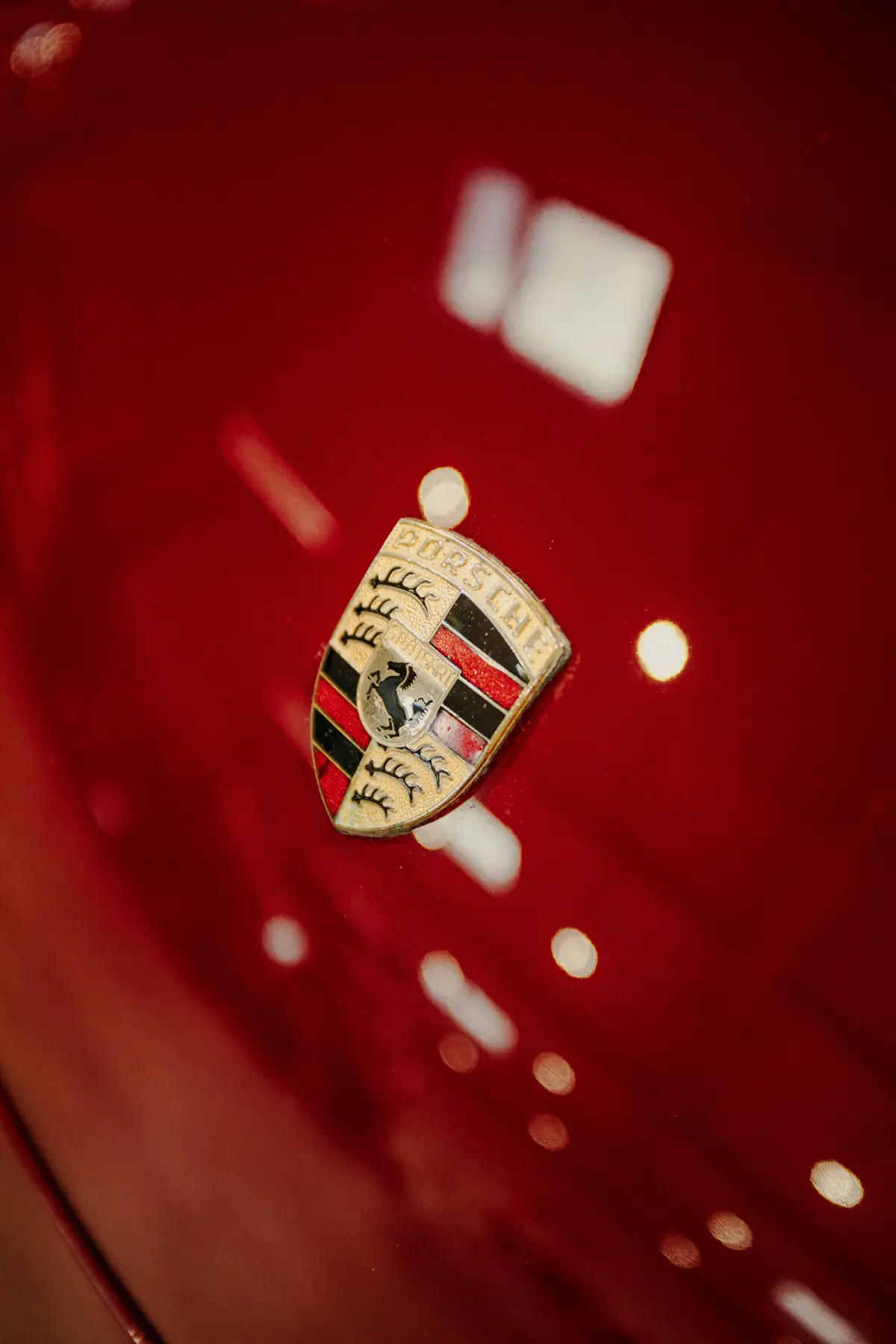 Porsche crest badge on a freshly finished hood at Kreations Auto Body