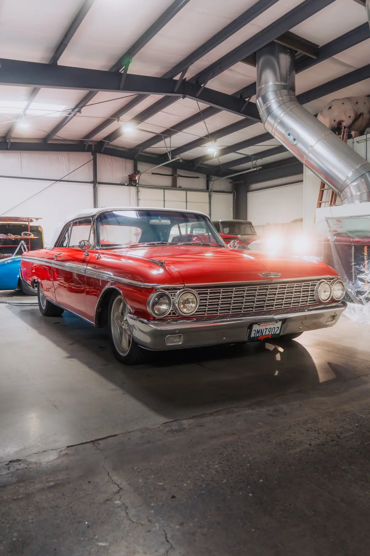 Restored red 1961 Chevrolet Impala in the Kreations Auto Body showroom