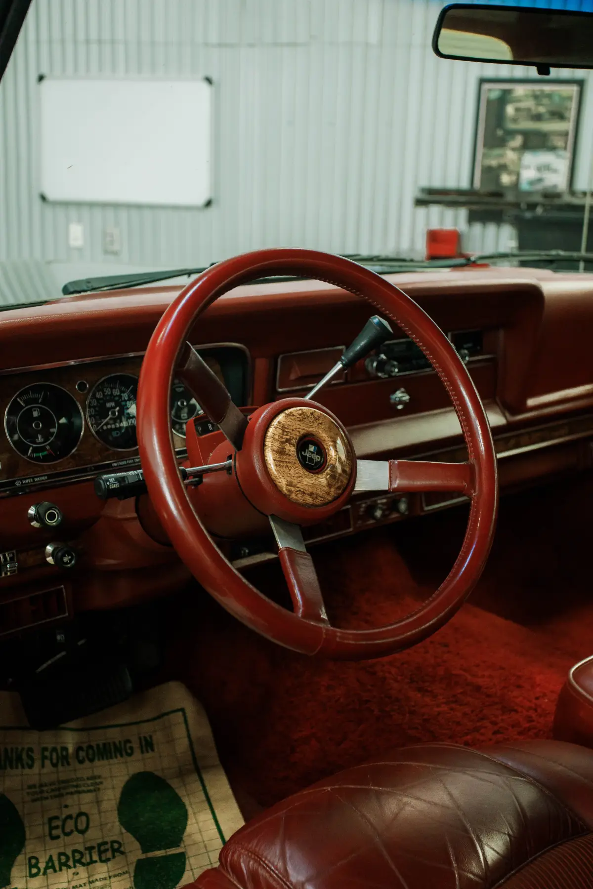 Wood-rimmed steering wheel and red interior in a Kreations Auto Body restoration