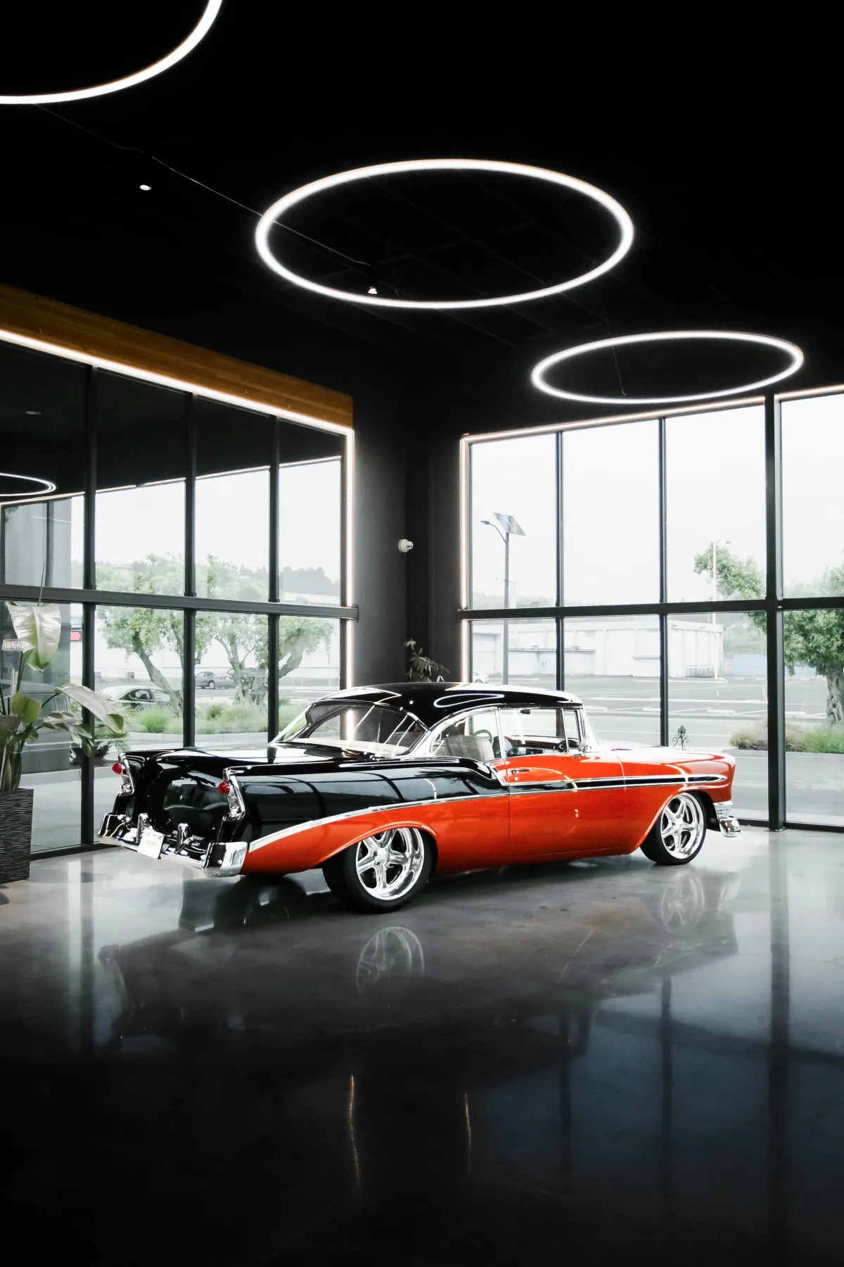 Restored orange-and-black classic Chevrolet Bel Air in the Kreations Auto Body showroom